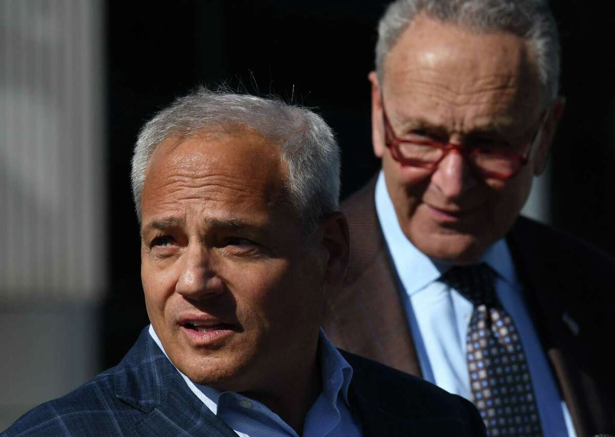 Tom Caulfield, CEO of GlobalFoundries, left, joins U.S. Senate Majority Leader Charles Schumer, right, in calling for legislation that would block China’s semiconductor supply from entering the U.S. defense sector and boost state chip manufacturing on Tuesday, Oct. 18, 2022, during a press conference at Albany NanoTech Complex in Albany, N.Y. GlobalFoundries is reportedly looking at job cuts despite the federal help.