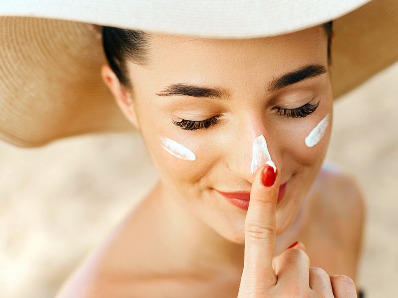 Woman applying sunscreen on her nose