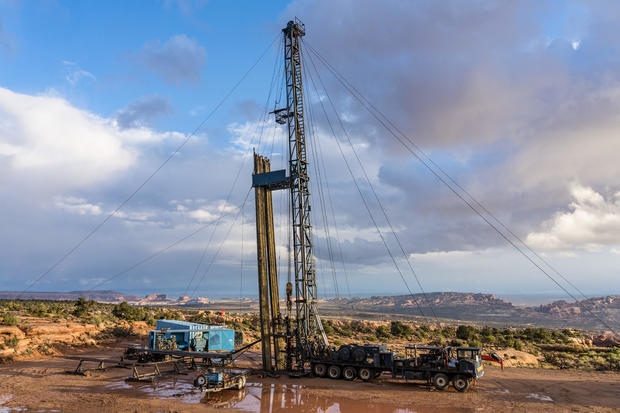 A pulling unit or workover rig on an oil well in Utah. Behind are the Monitor & Merrimac Buttes & Book Cliffs.. (Photo by: Jon G. Fuller / VWPics/Universal Images Group via Getty Images)