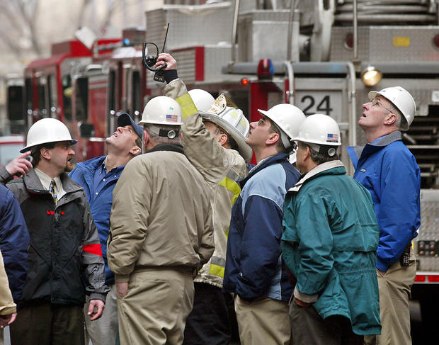 Construction engineers consult with a Boston fire chief at the scene of a structural collapse at a parking garage on the grounds of Mass General Hospital