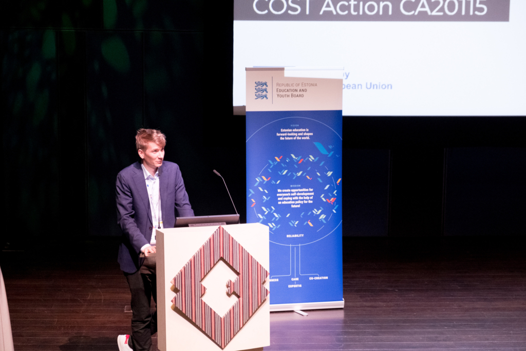 Photo of a young man on a stage during a presentation