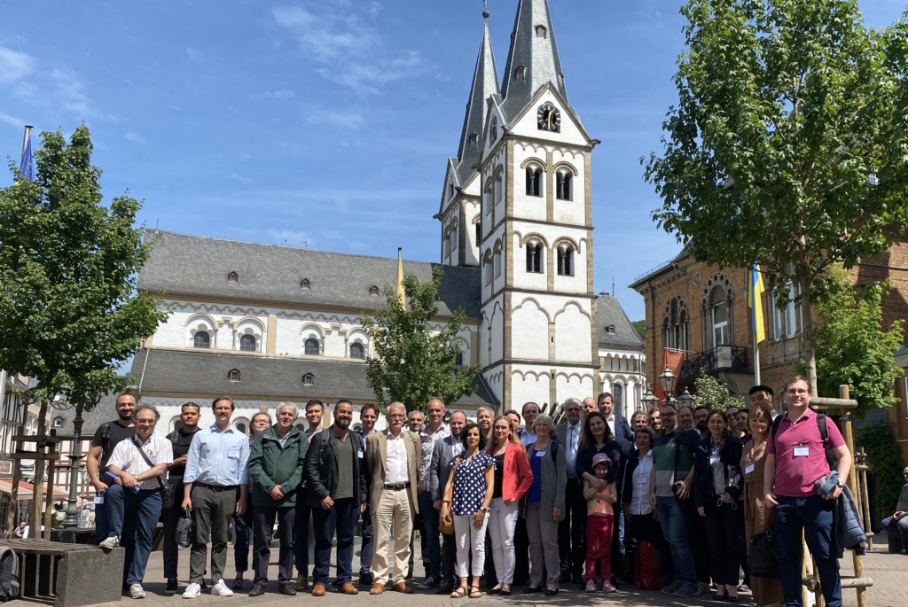 A group photo taken outside in front of a church on a sunny day.